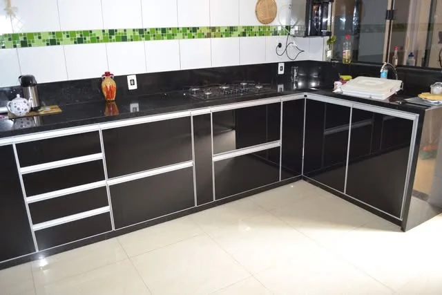 Cozinha com armários de portas em vidro preto e perfis de alumínio