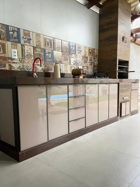Bancada de área gourmet com armários em vidro e alumínio e azulejos decorados